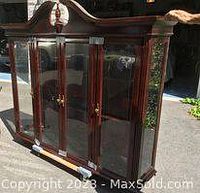 Front and angled side view showing cherry wood China cabinet, curved top molding, etched glass doors with brass handles and bottom drawers.