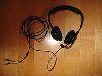 Front view of the Sennheiser PC310 gaming headset showing ear cups, adjustable headband, microphone boom, and coiled cable with audio connectors.