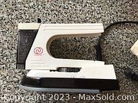 Side view of a compact white travel iron showing the black soleplate and cord outlet.