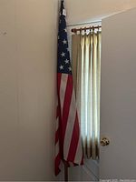 Photo of 90-inch tall American flag on wooden pole standing near window