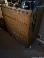 Front three-quarter view of the dresser showing three drawers and tapered legs