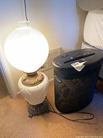 Photo of lit vintage table lamp next to black paper shredder showing overall size and condition
