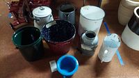 Group photo of nine metal containers including coffee pots, buckets, chamber pot, jug, and wall pitcher showing overall lot contents and condition with visible rust and wear.