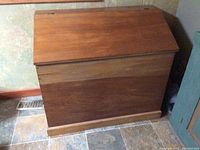 Front view of antique pine storage box showing the slanted top lid and overall shape.