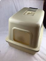 Covered cat litter box with flap door and vent on top.