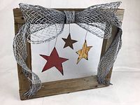 Frontal view of the wall art showing the wooden frame, mesh wire bow, and three hanging metal stars.