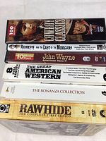 Photo of boxed DVD sets stacked to show titles including Cowboy Classics, Hawkeye and the Last of the Mohicans, John Wayne 10 Movie Pack, The Great American Western 8 Movie Collection, The Bonanza Collection, and Rawhide Complete First Season.