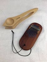 Photo of kalimba finger piano and pair of wooden spoons on white background
