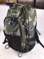 Front and side view of the large green camo Eddie Bauer backpack showing multiple compartments and mesh side pockets