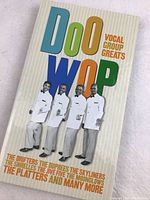 Front cover of the 3-CD Doo Wop Vocal Group Greats compilation album showing four male group members dressed in white suits and colorful title text.