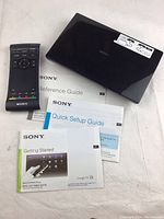 Sony Network Media Player device with remote control and three guide booklets laid out on a white surface.