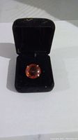 10kt gold ring with round amber stone in open black velvet ring box.