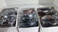 Three boxes of new sunglasses individually wrapped in clear plastic, assorted styles and lens colors visible