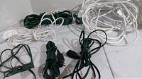 All six extension cords coiled on floor; multiple colors visible: white, green, black