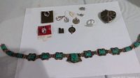Full lot showing all items spread on white surface including necklace, charms, ring, and pendant.
