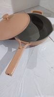 Peach colored ceramic skillet with lid open, showing interior and handle