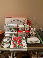 Full lot overview with all items including boxed salt and pepper shakers, vase, candle holders, creamer, sugar pot, butter dish, and napkins arranged on table