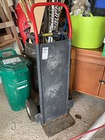 Full view of dolly showing red handle and black metal body.