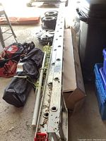 Side view of the ladder showing aluminum rungs and some debris on top.