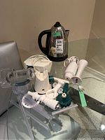 Image showing Russell Hobbs electric kettle, Black & Decker hand mixer, immersion blender attachments on a glass table.