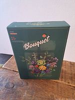 Front view of the green box featuring an image of the completed bouquet made from building blocks labeled 'Bouquet' by Alice