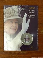 Colourized 2006 Canadian 25 cent coin in original packaging displaying Queen Elizabeth waving, noting the 80th Birthday celebration.