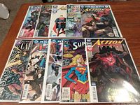 Ten DC comic books, all bagged and carded, laid out on wooden surface