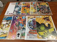Top-down photo of 10 Marvel comic books showing covers including Spider-Man, Quasar, X-Men, The Hulk, and more.