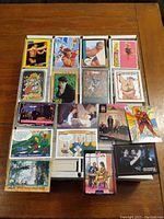 Photo showing an array of sample cards laid out on a wooden surface, featuring cards from various pop culture themes and different sets.