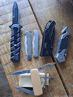 Top-down photo of all six folding tools laid out on wood surface