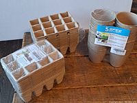 Seed starter trays and round pots made from biodegradable materials, labeled with SFEE brand and product details.