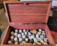 Open wooden box with 41 assorted collectible thimbles inside, showing various materials and decorative designs.