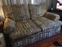 Full view of the Massoud love seat showing patterned upholstery and loose cushions.