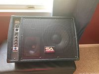 Front view of Seismic Audio FL-10 MP PW music amplifier showing mesh grille, SA logo, and black exterior.