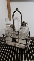 Full view of two crystal decanters in metal carrier with mirror and handle.