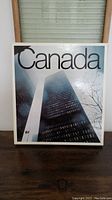 Front cover of the coffee table book showing modern tall buildings with 'Canada' title