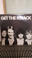 Front cover of 'Get The Knack' vinyl album showing a black and white photo of the band members.