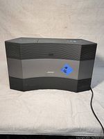 Front view of BOSE Acoustic Wave CD-3000 radio showing curved speaker grille and BOSE logo.