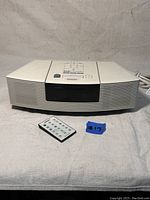 Front view of Bose Wave Radio/CD system with remote control placed in front.