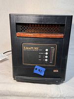 Front view of the EdenPURE heater showing control panel and wood accent above vents.