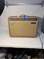 Front view of brown tweed amplifier showing full grille and control panel.