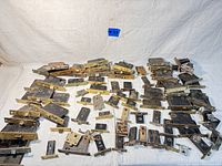 Photo showing the entire lot of approximately 50 antique door mortise locks arranged on a white fabric surface