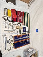 Wide overview of assortment including micrometers, calipers, dividers, dial indicators and storage boxes