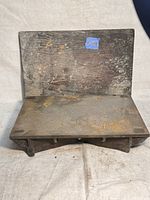 Photo showing front view of steel machinist layout inspection table with wooden cover, surface with scratches and rust.