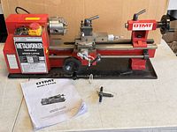 Overall view of lathe on bench with manual and tools