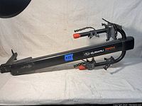 Full view of the black Yakima Subaru branded bicycle rack showing the main arm and securing straps.