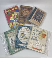 Books arranged, showing front cover of Simpsons Comics Spectacular, The Tales of Beedle the Bard by J.K. Rowling, The Wide Window, Little Bear books, and Johnny Lion's Book.