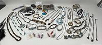 Full overhead view of the assorted jewelry pieces laid out on a flat surface showing the variety and quantity of items, including necklaces, bracelets, and earrings.