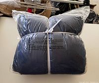 Clear plastic packaged king size navy and white sherpa blanket tied with white band showing new condition.
