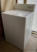 Front angle view showing the full washing machine unit with lid closed and control panel visible.